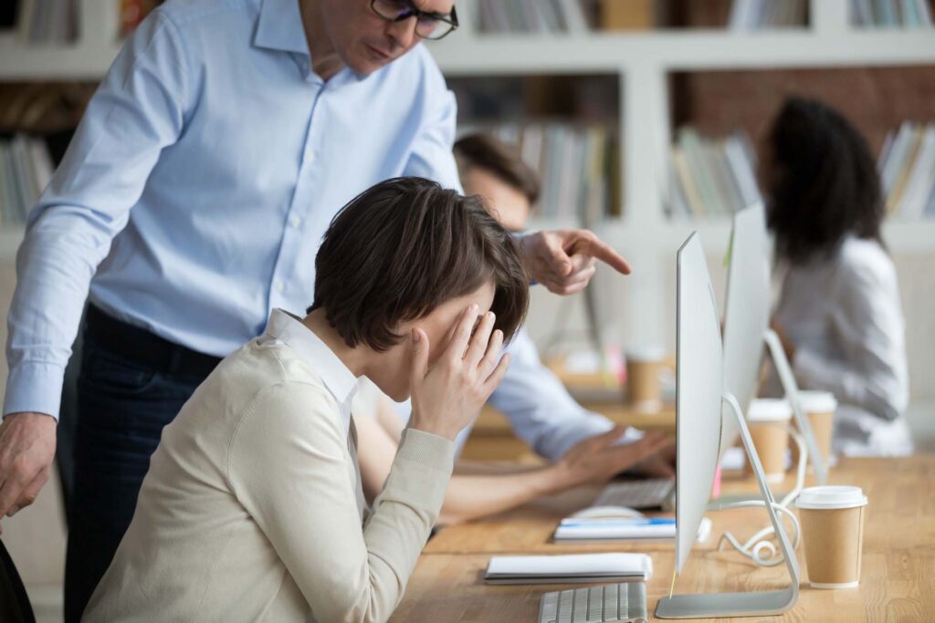 Stressed employee intern suffering from gender discrimination or unfair criticism of angry male boss shouting scolding firing female worker for bad work, computer mistake or incompetence in office